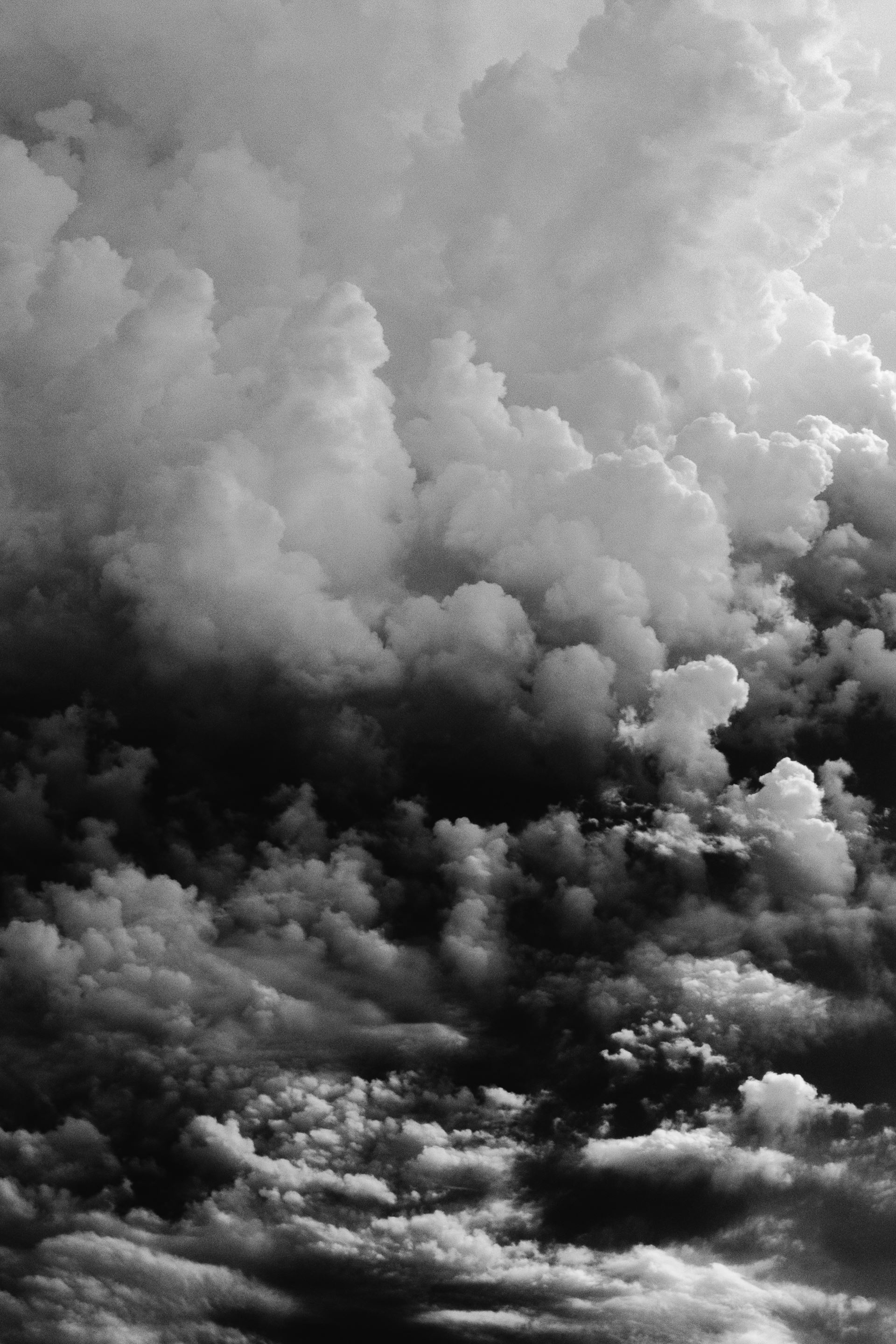 a group of clouds in the sky with smoke coming out of it